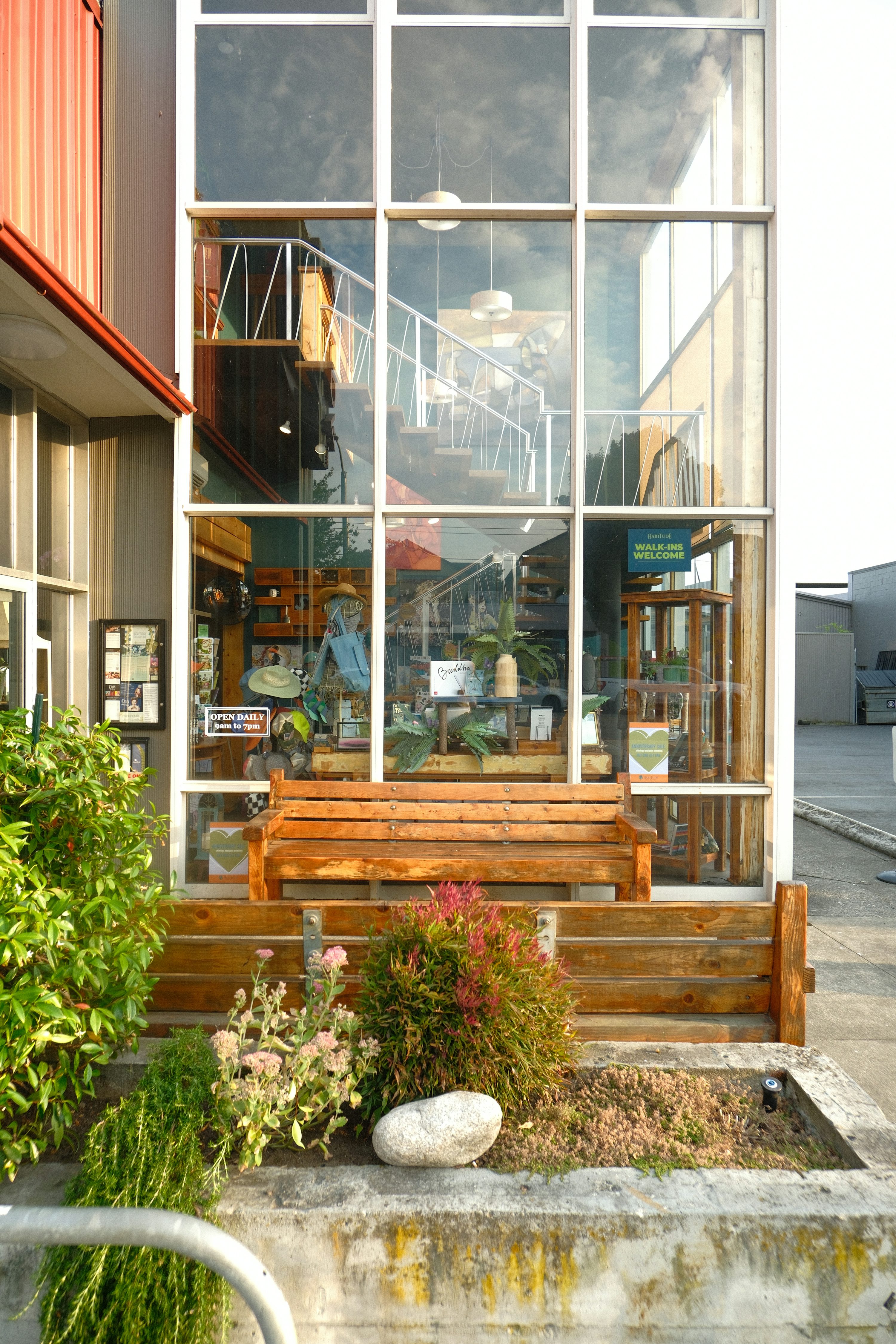 A storefront window and bench outside a small business.